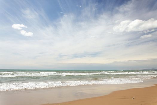 Sandy beach with waving sea