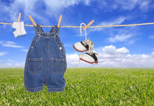 Baby Boy Child Clothes Hanging Outdoors Against a Bright Blue Sky