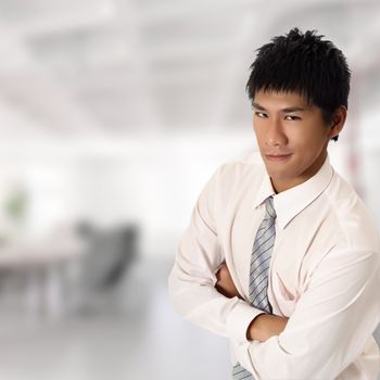 Handsome Asian businessman looking and smiling in office.