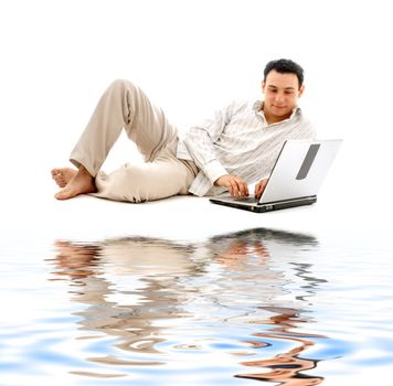 relaxed man with laptop computer on white sand