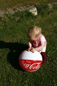 child playing with a ball marked Coca-Cola.