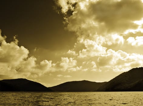 Sepia toned image of mountains lake and cloudy sky