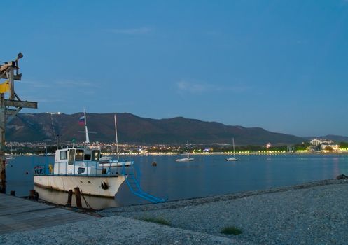 fisherman's boat in the harbour in a small town on the beach. Night view