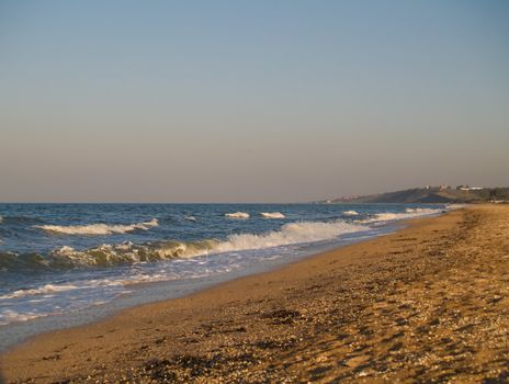 Desolated seabeach witch clear sky and waves