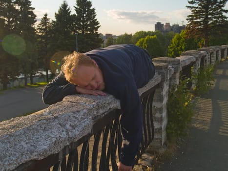 eccentric man sleeping on a parapet and see wonderful dreams