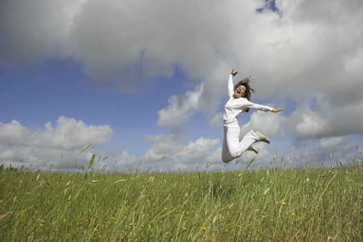 Beautiful woman having fun in the nature, making a big jump