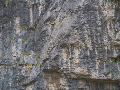 Close-up photo of the gray textured wall of cliff