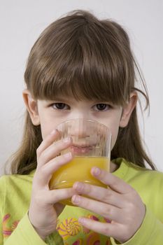 little cute adorable girl seven years old drink orange juice
