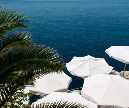 Shade provided by umbrellas on patio by ocean