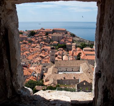 View over rooftops of Dubrovnik to tower and distant ocean