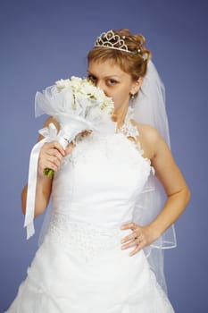 Young Bride smell the flowers on a blue background