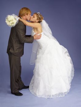 The bride and groom funny kiss on purple background