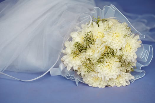 Wedding bouquet and veil on a blue background