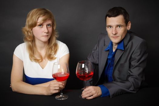 Man and woman drinking red wine in the evening at the table