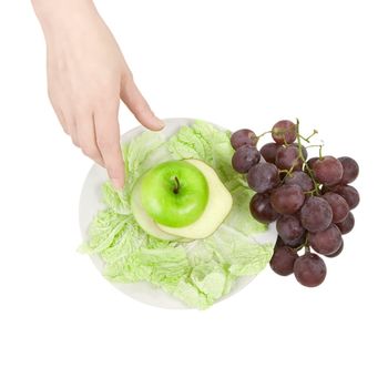 The hand reaches for fruit lying on a plate