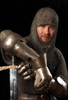 The soldier in a medieval knightly armour with we throw in hands
