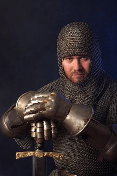 The soldier in a medieval knightly armour with we throw in hands