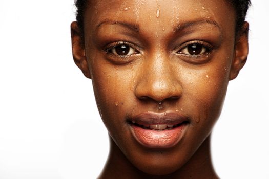 African woman with natural make-up headshoot with drops on her skin