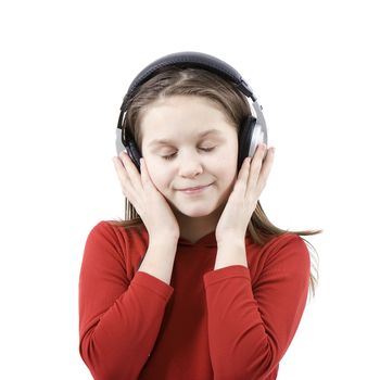 On white background the girl in the big ear-phones listens to music and smiles