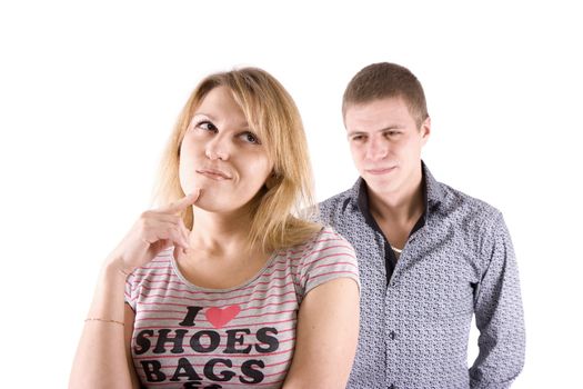 The man argues with the woman. The woman in the foreground grins.