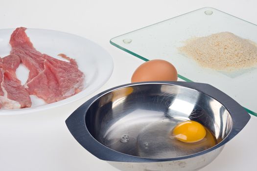 making a viennese schnitzel isolated on white