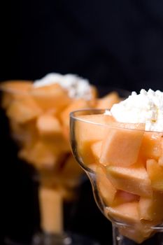 cantaloupe cut and in parfait glass dark background