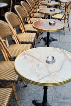 Round tables and chairs in cafe in Paris. Photo with tilt-shift effect