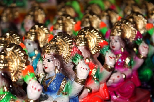 Small colorful idols of Goddess Laxmi in a potters workshop during Diwali festival.