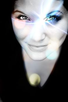 An abstract womans portrait with a glowing lens flare on her face.