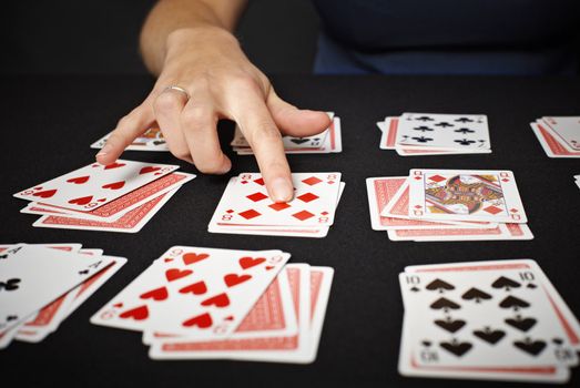 Cartomancy. Black background, a woman's hand close up.