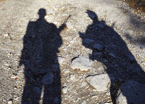 On the ground the shadow of two armed men