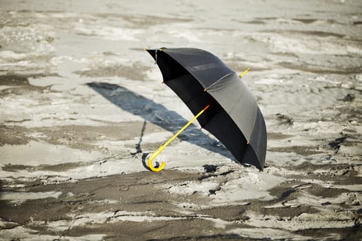 Large old-fashioned black umbrella in the desert