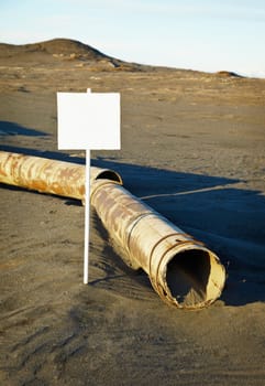 A sign near the old rotting pipe - an ecological disaster