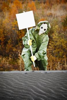 Scientist in protective suit and gas mask carry poster