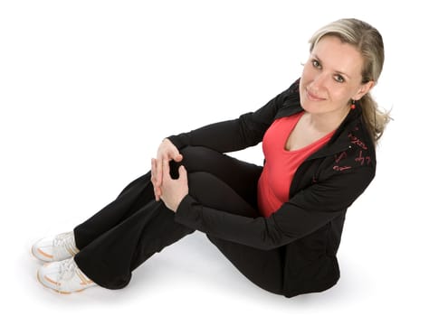 Young women with sportswear sitt on the floor. White background