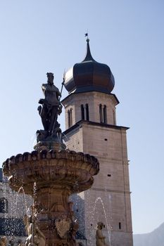view from Piazza Duomo of the Nettuno fountain with the bell tower of Duomo in background, Trento, Italy