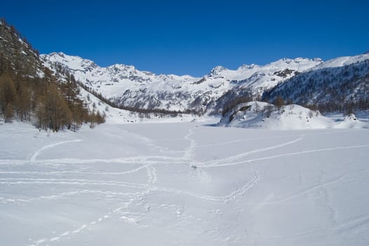icy alpine lake landscape full of snow; Alps, Italy