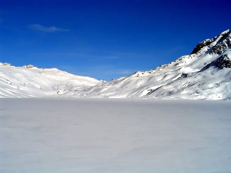 A frozen lake (Toggia) covered of snow in Val Formazza, Ossola, Itlay