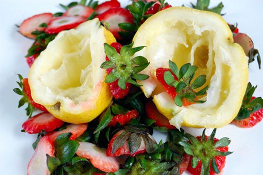 closeup of fruits (lemons and strawberries) scraps on a table.