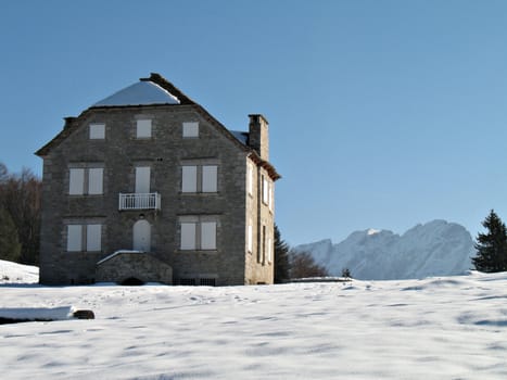 house of stones in the snow in mountain in a wonderful sunny day