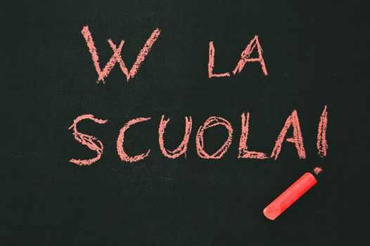 blackboard with the notice "W LA SCUOLA" and a red chalk