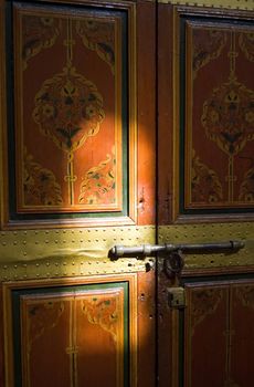 A painted door of the Bahia Palace in Marrakesh with light reflection, Moroc