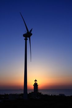 a lighthouse, a wind turbine and a sunset