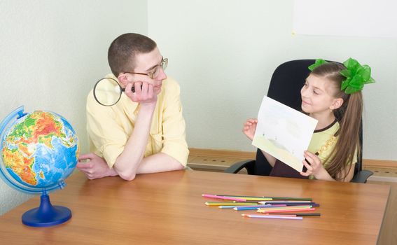 The girl shows new drawing to the brother