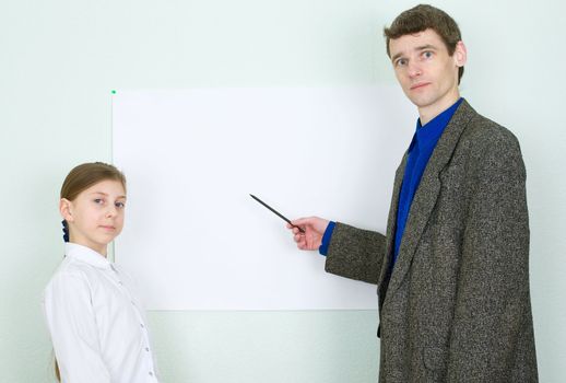 Teacher explains something to the schoolgirl showing on the poster