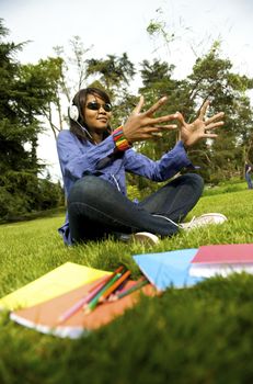 Black woman listening to the music in a park with white headphones