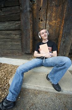 Man listening to the music in a park with white headphones