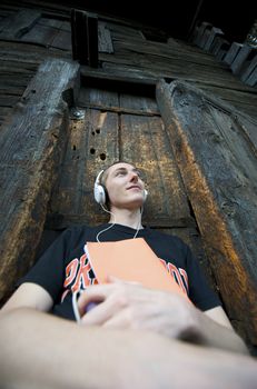 Man listening to the music in a park with white headphones