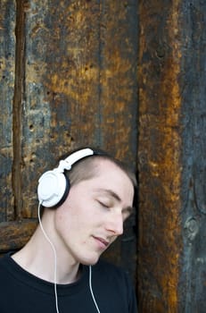 Man listening to the music in a park with white headphones