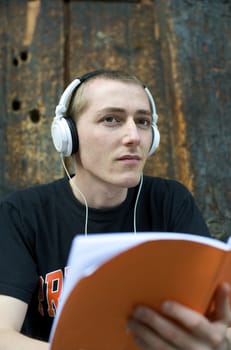 Man listening to the music in a park with white headphones